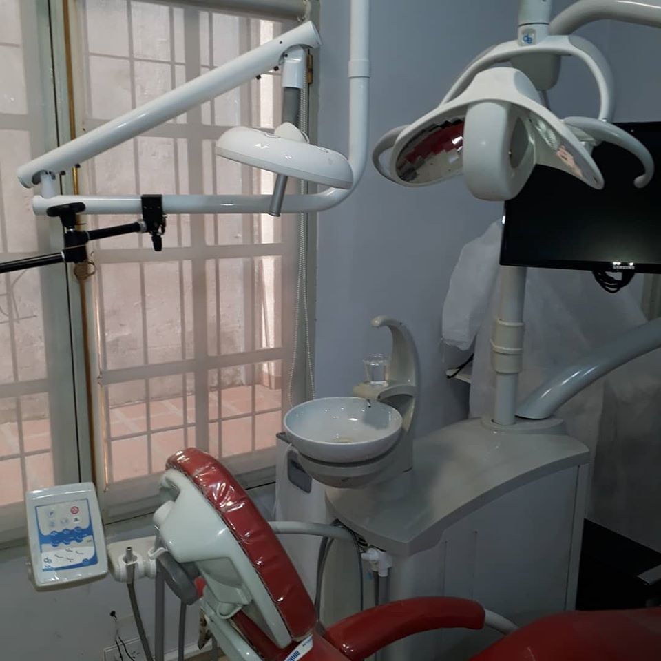 Clinical treatment room equipped with high end teal ergonomic patient chair and surgical lamps